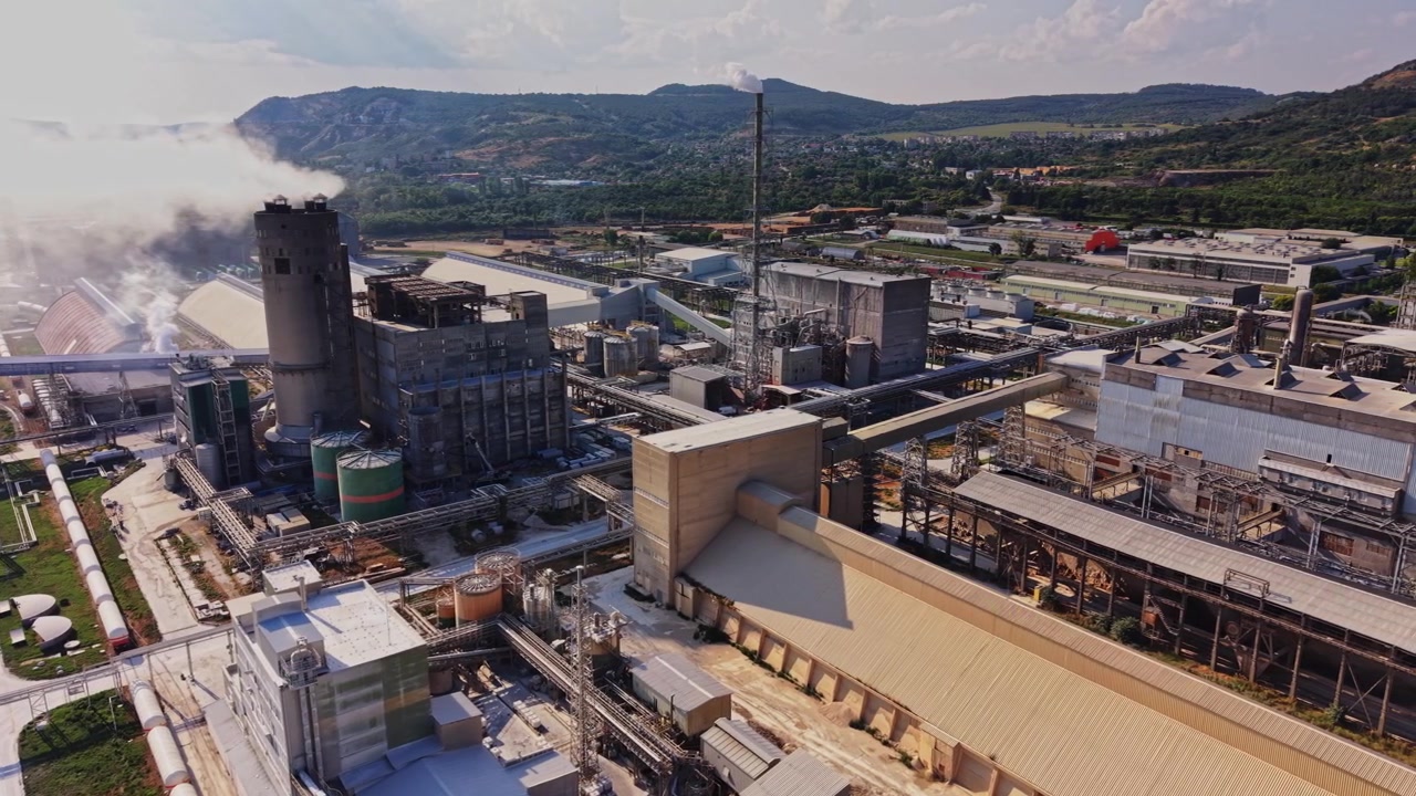 Complesso industriale con fumo e macchinari sullo sfondo