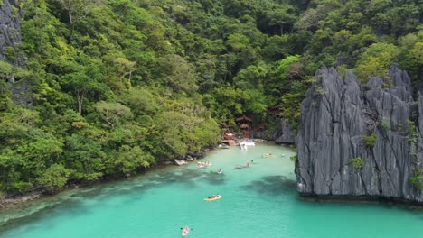 Touristen-Fahren-Kajak-Auf-Der-Kristallklaren-Cadlao-Lagune-Im-Exotischen-Karstfelsen-Und-In-Der-Insellandschaft-Von-El-Nido-Palawan