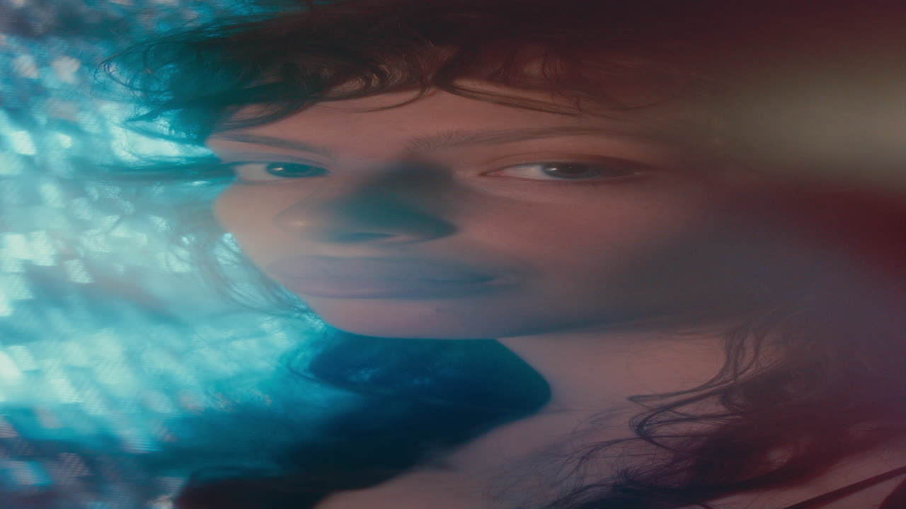 Portrait of Young Pretty Woman Posing in Dreamlike Blue Light Glow