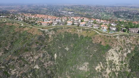 slow aerial drone flying back from luxury homes in laguna niguel, orange county, california showcasing hills