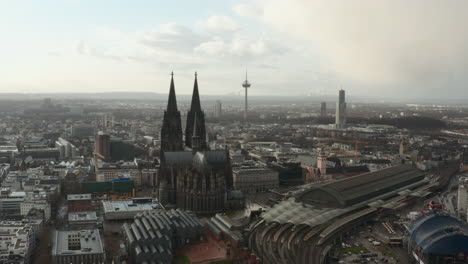 Imágenes-Aéreas-De-Diapositivas-Y-Panorámicas-De-La-Iglesia-Catedral-De-San-Pedro,-La-Estación-De-Tren-Y-Los-Edificios-Circundantes.-Colonia,-Alemania