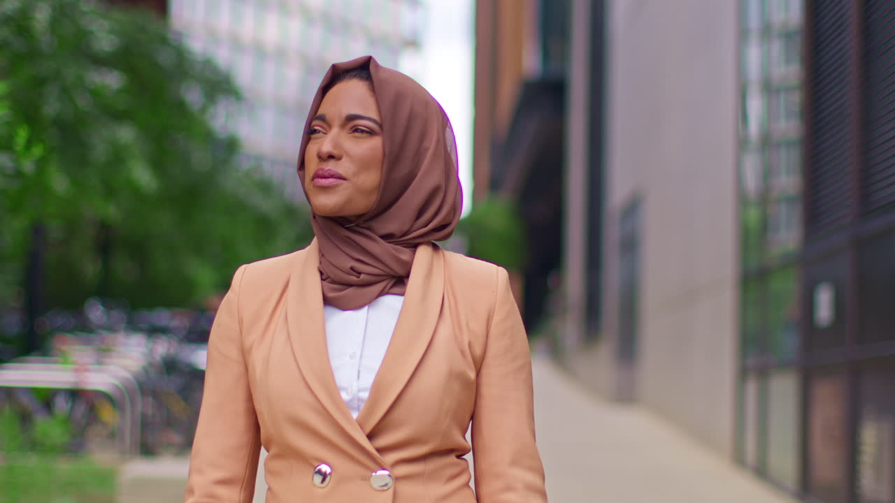 Close Up Of Modern Muslim Businesswoman Wearing Hijab With Business Suit Walking To Work Past Office Buildings