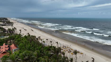 foamy waves wash over beach by fortaleza in brazil, aerial pan