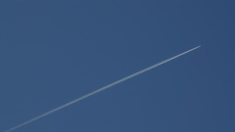 shot of a plane vapour trail, contrail at cardigan bay on new quay beach