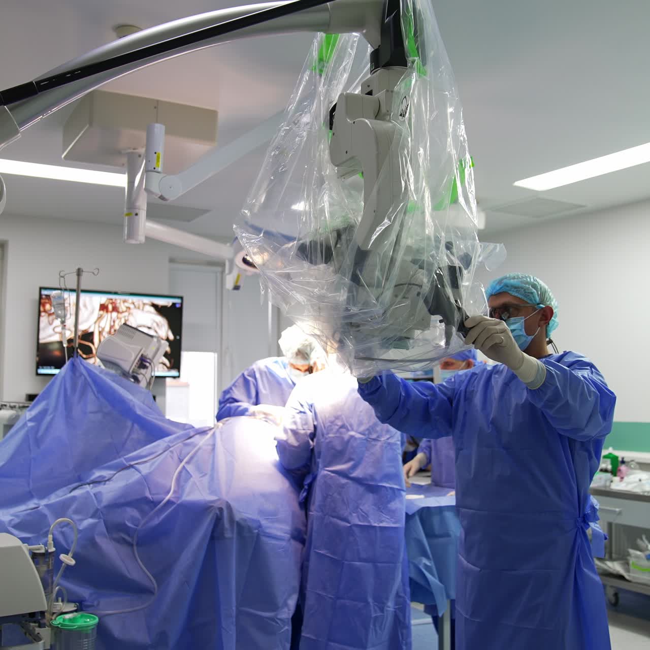 Surgical procedure in progress. Team of doctors working in the operational room. Surgeon prepares microscope for usage at surgery