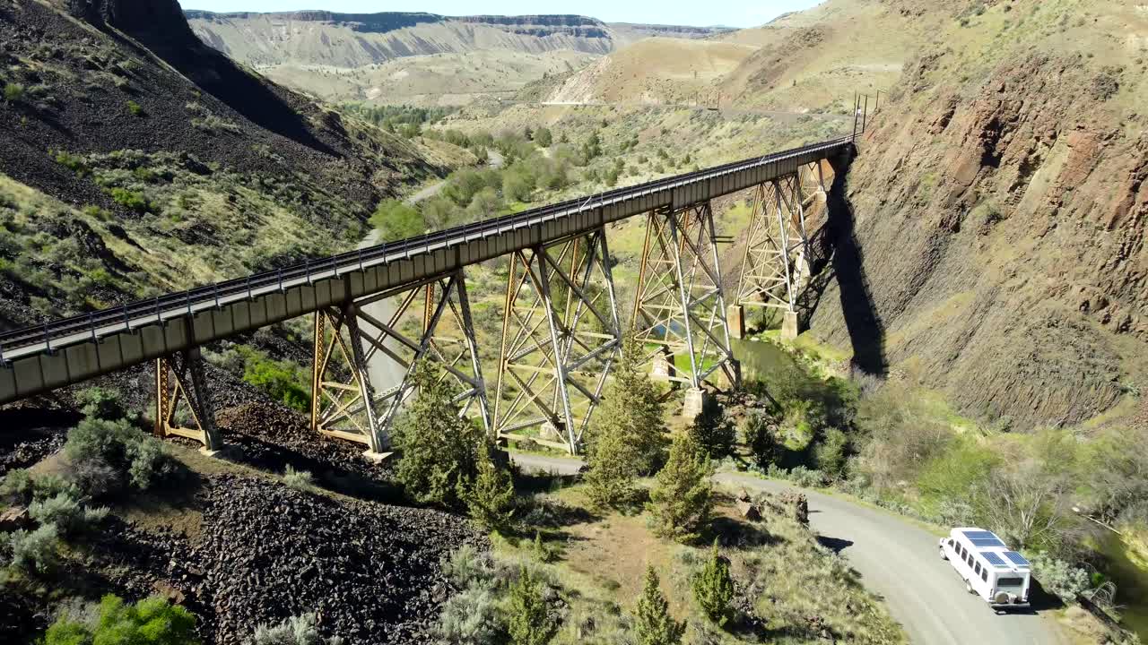US, Oregon, Madras, Trout Creek, 2025-04-19 - Drone view of a steel train trestle bridge over the creek in the springtime in central Oregon.