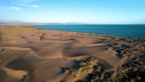 orbital drone shot of people practicing sandboard in the dunes of mogote in baja california sur mexico