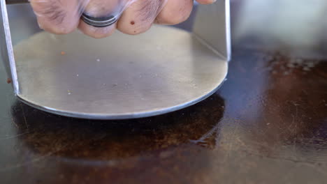 pressing a piece of meat on the grill - high angle - close up