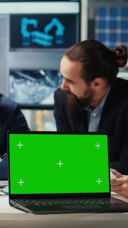 vertical video factory engineers using green screen laptop to increase energy output