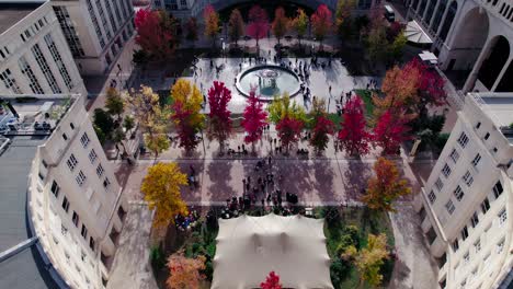 Aerial-dolly-shot-of-people-walking-past-a-water-fountain-at-the-Zone-Atristique-Temporaire