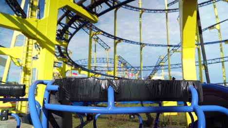 Cars-and-train-of-closed-roller-coaster,-in-an-abandoned-funfair-during-Coronavirus-Covid-19-pandemic-lockdown,-empty-scenery-in-an-amusement-park