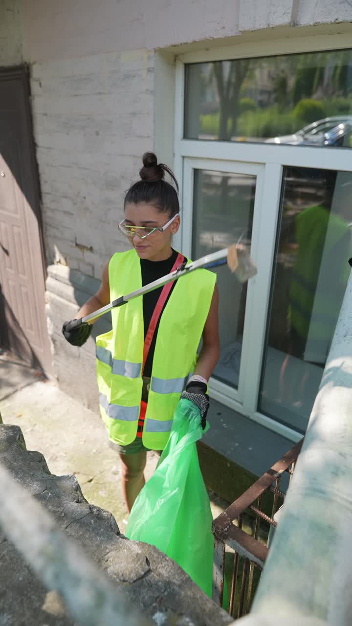 mujer limpiando la basura en la calle