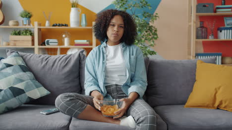 teenager watching tv and eating chips