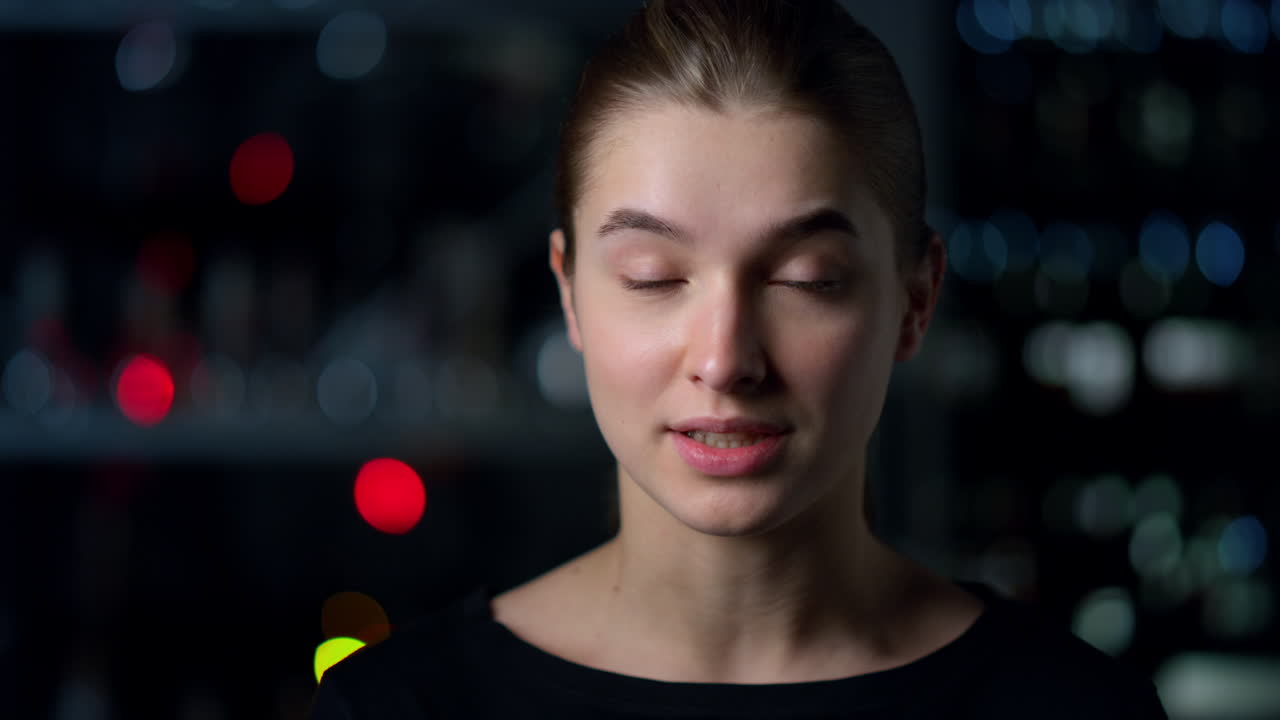 Portrait of young woman looking at web camera recording video. Video chatting.