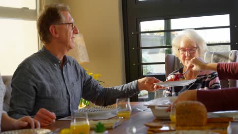 Hombre-Mayor-Sirviendo-Plato-De-Comida-A-Una-Mujer-En-La-Mesa-Del-Comedor-4k