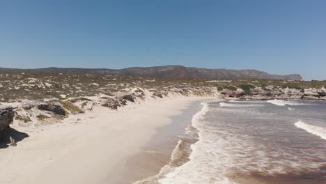 aerial: long beach shot of south african coast with white sand and rocks