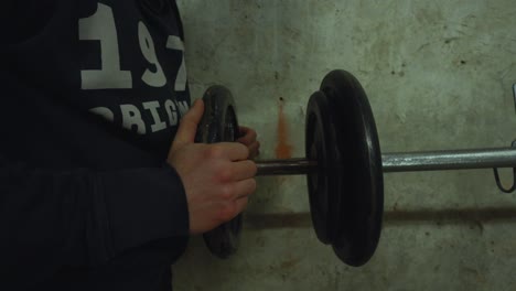 bodybuilder prepares to execute chest exercise by setting weights on bench press