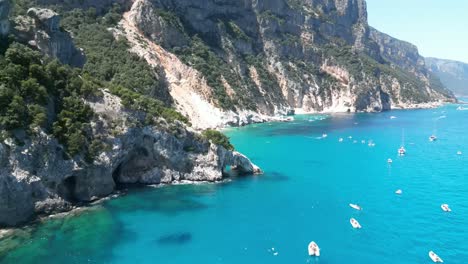 Cala-Goloritze-shore-crowded-with-boat-tourism,-Sardinia