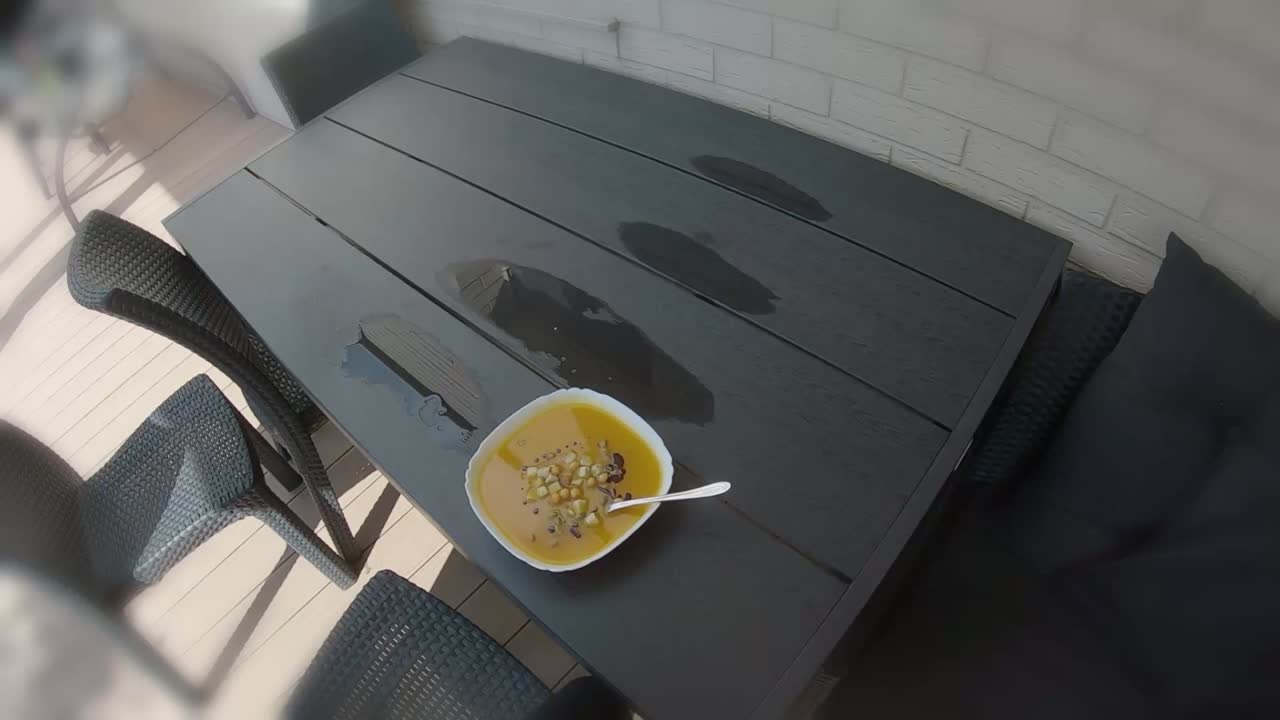pov en primera persona comiendo sopa de calabaza naranja afuera