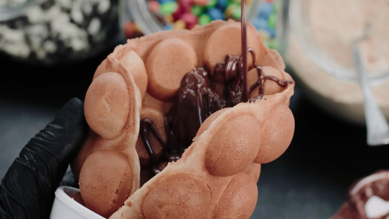 거품 와플에 뜨거운 녹은 초콜릿을 붓는