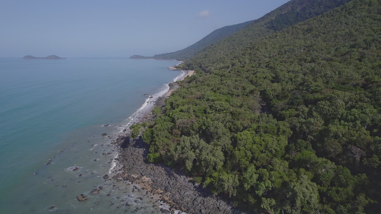 océano turquesa y exuberante selva tropical en la playa fronteriza en wangetti, qld, australia - toma aérea de drones
