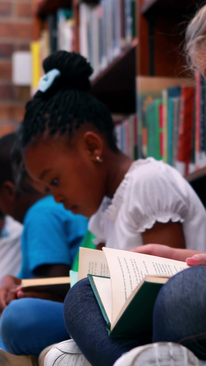 Animation of school icons moving over school children reading books