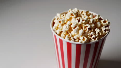 popcorn in a red and white striped bucket