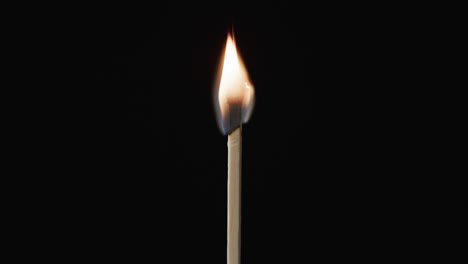 Video-of-close-up-of-match-with-yellow-fire-flame-and-copy-space-on-black-background