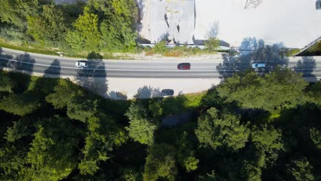 Stunning-aerial-4k-drone-footage-of-a-curvy-road,-forest-and-cars-driving-on-it-in-summertime