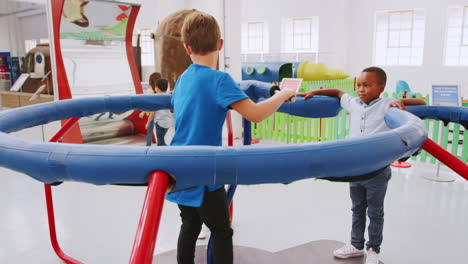 dos niños en un experimento de fuerza centrífuga en el centro de ciencias