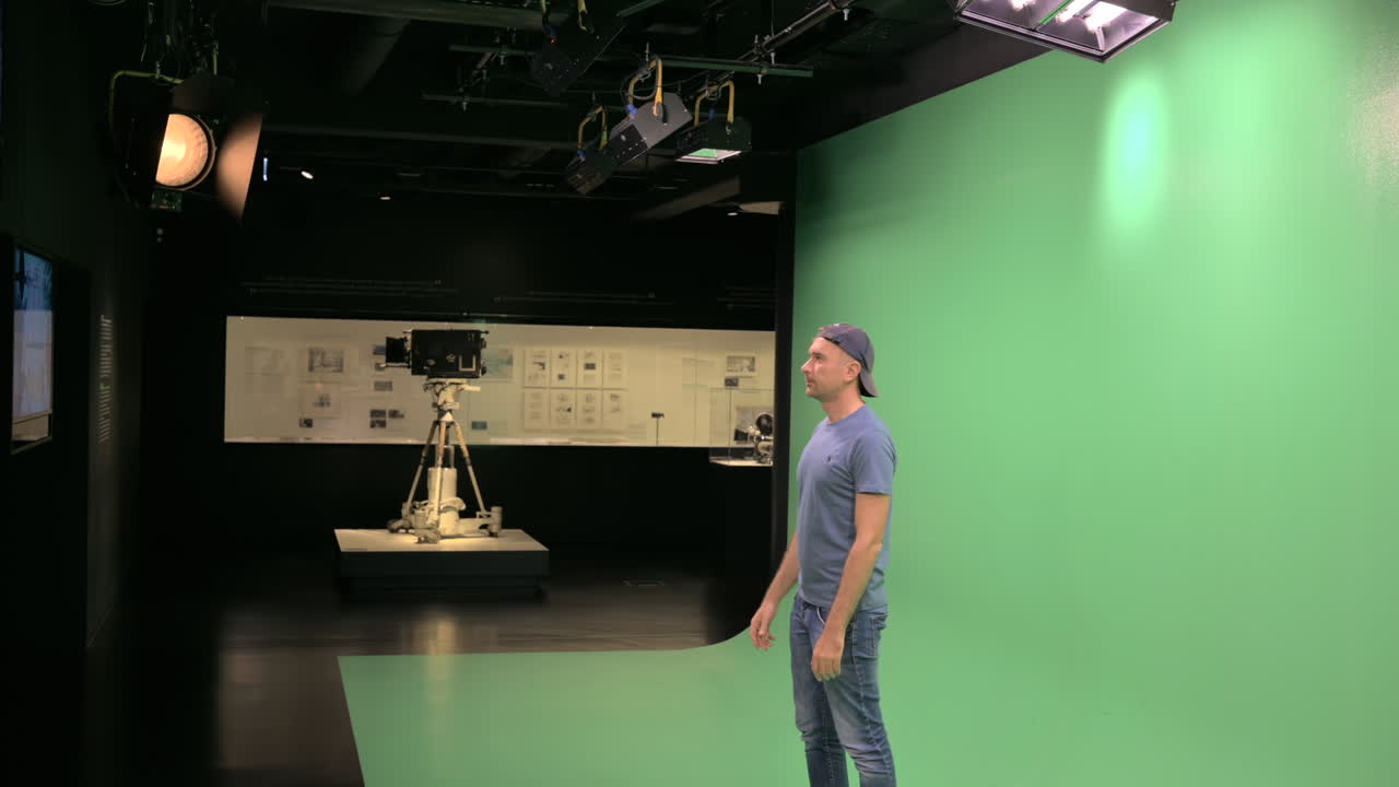 Man moving in front of a green screen in a studio