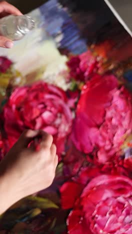 close-up of an artist painting a bouquet of peonies