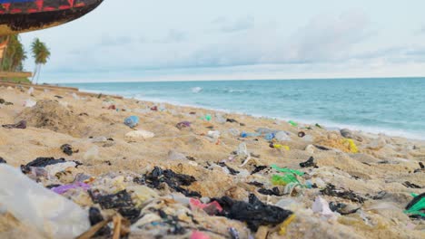 established of marine pollution, plastic bottle waste and bags on tropical sand beach with ocean sea waves on background