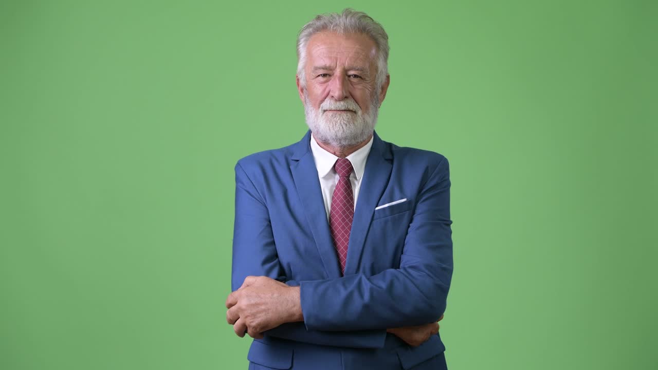 Affascinante uomo d'affari anziano con barba su sfondo verde