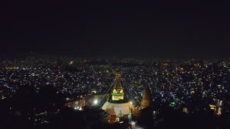 The-drone-orbits-around-Swayambhunath-Stupa,-known-as-Monkey-Temple,-showcasing-the-beauty-of-Kathmandu-at-night-during-Tihar-Light-festival