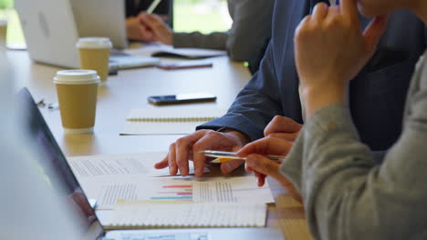 multi-cultural business team meeting and collaborating around table in modern office building