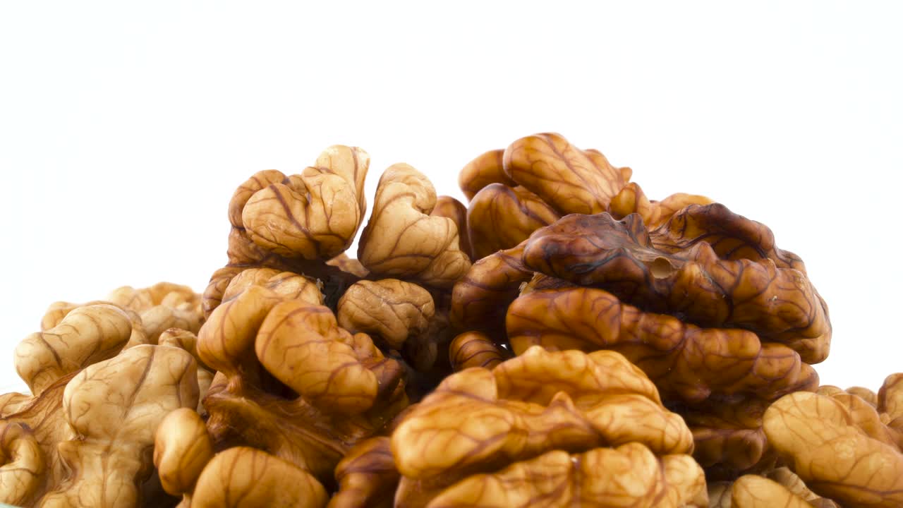 Pile of walnuts without the shell. Rotating on the turntable isolated on the white background. Close up. Macro.