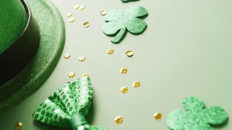 animation of st patrick's green hat, shamrock and bow tie with copy space on green background