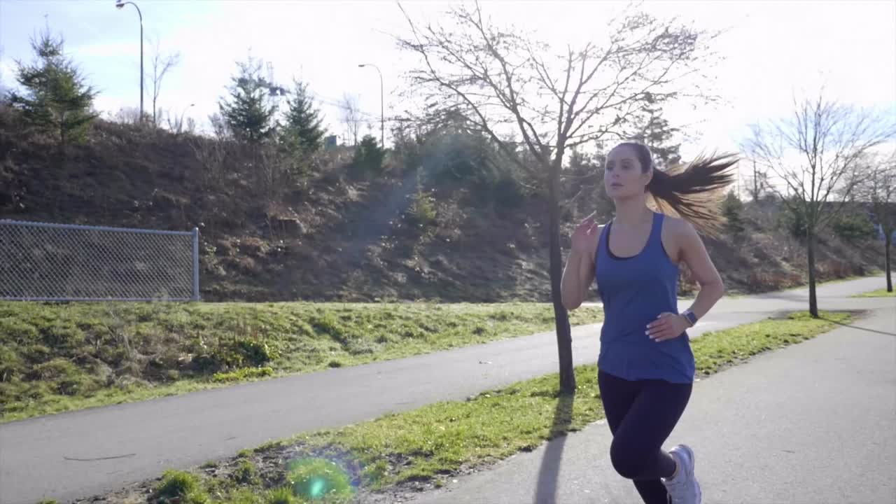 mujer joven atlética corriendo a lo largo de tiro de seguimiento de cardán