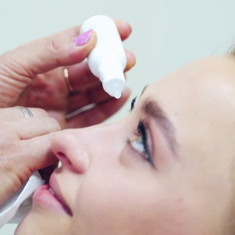 eyes treatment in clinic. ophthalmologist treats patient's eyes. doctor's hand drips medicine into woman's eye. close-up.