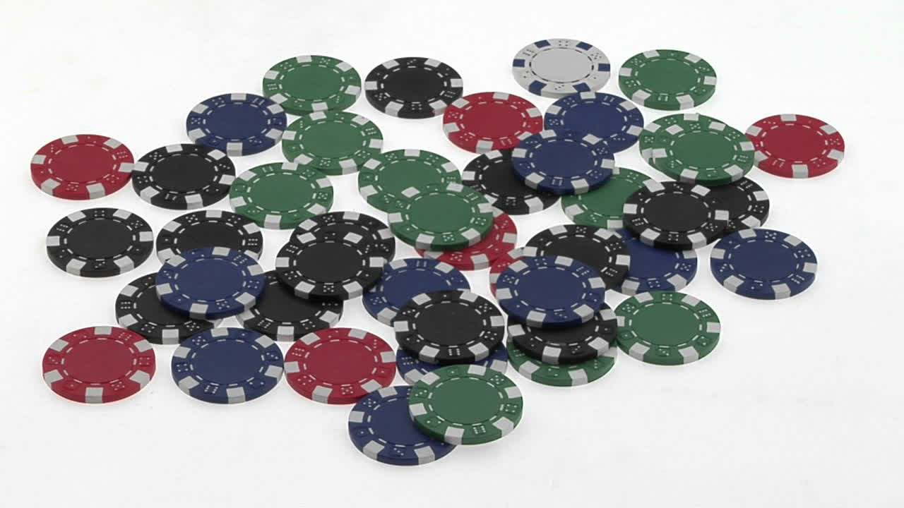 A poker player's hands gather a pile of poker chips
