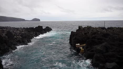 la piscina natural de varadouro, el océano atlántico y el morro do castelo branco en el fondo