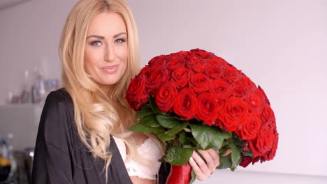 Smiling-Woman-in-Sleepwear-Holding-a-Rose-Bouquet