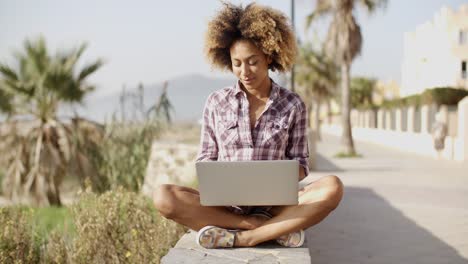 Niña-Navegando-Por-Una-Computadora-Portátil-En-Un-Banco