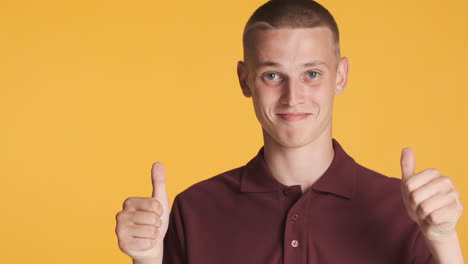 smiling boy pointing aside and giving thumbs up