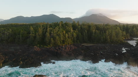 Drone-video-at-sunset-in-Ucluelet-British-Columbia,-Canada-over-the-ocean-and-forest