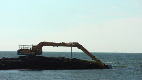 Hydraulic-Excavator-Dredging-Silt-From-Ocean-Bay-Coastline,-SLOW-MOTION