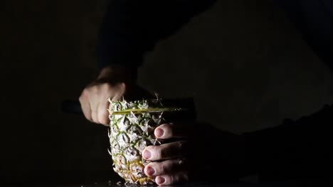 Time-Lapse-of-Male-Slicing-Pineapple,-Ananas-With-a-Knife-in-The-Dark