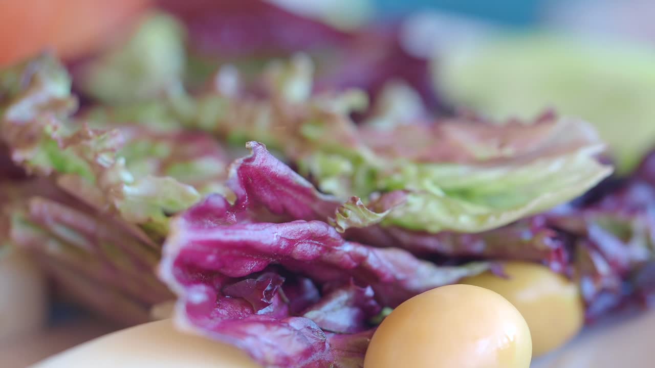 Close-up of a salad with tomato, lettuce, and olives