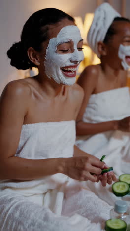 women enjoying a relaxing home spa day with face masks and cucumber slices